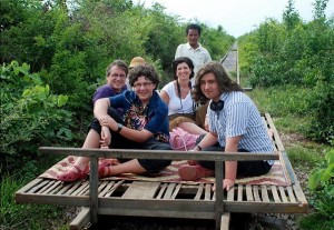 Tourists are sitting on a straw mats that have been laid over bamboo platforms.