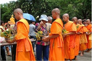 Monks receive food brought by people